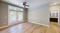 Located at 305 Heywood Shores Dr in Arden, NC, this 2-bedroom, 2-bathroom residence offers a thoughtfully designed single-floor layout that balances comfort and functionality. Light hardwood flooring flows consistently throughout the space, creating a bright and cohesive aesthetic.

The kitchen is a standout feature, equipped with rich dark-toned cabinetry, light quartz-style countertops, black appliances, a tile backsplash, and a peninsula with a built-in sink and pendant lighting overhead — ideal for both cooking and casual dining.

The living area benefits from generous natural light courtesy of French doors that open to the outdoors, complemented by a ceiling fan. Both bedrooms are comfortably sized, with the primary bedroom offering a dedicated closet and direct access to its own bathroom. Each bedroom includes a ceiling fan and windows framing lush greenery outside.

The two bathrooms are consistently finished with dark wood vanities, light countertops, and wood-look flooring. One bathroom features a tub/shower combination, while the other includes a large framed mirror and ample cabinet storage.

A dedicated closet and hallway complete the layout, adding practical storage and easy circulation throughout the residence. The overall ambiance is clean, modern, and move-in ready.