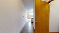 Located at 5120 Brookside Dr, Unit #203, in Madison, Wisconsin, this 480-square-foot, one-bedroom, one-bathroom apartment offers a well-designed layout across a single floor. The open-concept kitchen and living area serves as the heart of the unit, featuring warm medium-toned wood cabinetry, a full suite of stainless steel appliances including a refrigerator, electric range, and built-in microwave, complemented by neutral countertops and a peninsula with a dual-basin sink. Durable hardwood-style flooring runs throughout the kitchen, while plush neutral carpet extends across the living area and bedroom. Track lighting overhead enhances the open feel of the main living space. The bedroom, spanning 80 square feet, offers a window with exterior views, providing natural light, and includes a built-in closet with wire shelving for organized storage. The full bathroom is finished with large-format tile flooring, a combined tub and shower, a wood-toned vanity with a white countertop, and a wall mirror. Warm wood baseboards and cream-toned walls carry a consistent, clean aesthetic throughout the unit, making this an efficient and functional space in Madison's Brookside community.
