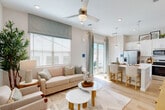 Located in Buckeye, AZ, this single-story 2-bedroom, 3-bathroom home offers a thoughtfully designed open-concept layout with a clean, modern aesthetic throughout. Light wood-tone flooring flows seamlessly across the living spaces, complementing the neutral, warm color palette.

The combined kitchen and living area serves as the heart of the home. The kitchen is outfitted with white shaker cabinetry extending to the ceiling, white subway tile backsplash, quartz countertops, stainless steel appliances including a French door refrigerator, gas range, microwave, and dishwasher, and a large breakfast bar with pendant lighting. The adjoining living room features a ceiling fan, large windows with natural light, and a sliding glass door providing access to the outdoor patio area.

A bright, functional hallway connects the bedrooms and bathrooms, with an in-unit stacked washer and dryer conveniently tucked along the corridor. The primary bedroom is generously sized with a ceiling fan, natural light from a window, and access to an en-suite bathroom. The second bedroom mirrors the same comfortable, airy feel. Three well-appointed bathrooms serve the home, each featuring clean white finishes. Additional storage is provided through three closets and a pantry.