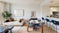 Located at 325 15th Street in Jersey City, NJ, this well-appointed one-bedroom, two-bathroom residence offers a thoughtfully designed layout across a single floor. Light wood flooring flows throughout, complementing a neutral color palette that gives the space a clean, modern feel.

The open-concept living and dining area is anchored by expansive floor-to-ceiling windows that flood the space with natural light and frame sweeping city and skyline views. The kitchen features two-tone cabinetry — warm wood lower cabinets paired with high-gloss white uppers — a striking marble-patterned backsplash, quartz countertops, stainless steel appliances, and a generous breakfast bar with seating.

The primary bedroom is a serene retreat with its own floor-to-ceiling window offering city views, a dedicated closet, and ample room for a large furniture arrangement. A versatile office provides a quiet, separate workspace with light wood flooring and ceiling lighting. The two bathrooms are finished with elegant marble-style tile surrounds — one featuring a glass-enclosed walk-in shower, the other a full soaking tub with shower combination. The residence is completed by a well-sized closet for additional storage.
