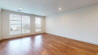Located at 704 Williamson Street in Madison, WI, this well-appointed one-bedroom, one-bathroom unit offers a thoughtfully designed open-concept layout across a single floor. The combined kitchen and living area serves as the heart of the home, showcasing warm hardwood flooring, recessed lighting, and large windows that invite generous natural light and outdoor views. The kitchen is a standout feature, equipped with dark espresso cabinetry, stainless steel appliances including a refrigerator, range, and microwave, and a granite-topped island with an integrated sink and pendant lighting overhead — ideal for both everyday cooking and casual dining. A glass-paneled exterior door in the living area adds additional light and access. The hallway, also finished in hardwood, connects the main living space to the private quarters. The bedroom offers plush carpeting, a ceiling fan, and dual windows that frame outdoor views, creating a bright and comfortable retreat. An adjacent closet provides dedicated storage. The bathroom is finished with dark cabinetry, a white countertop vanity, a large mirror, tile flooring, and a full soaking tub with shower. Clean lines and a neutral color palette throughout lend the space a modern, cohesive aesthetic.