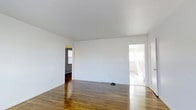 This 1-bedroom, 1-bathroom residence is designed with simplicity and functionality in mind, offering a comfortable and practical living environment across a single floor. The main living area is a standout feature, showcasing warm, richly toned hardwood floors that run throughout, adding character and a timeless appeal to the space. Smooth white walls and a clean white ceiling create a bright, open atmosphere that maximizes the sense of space. Natural light filters in through windows, lending an airy quality to the interior. The layout connects the living area to the bedroom and bathroom through open doorways, allowing for easy flow between rooms. The bedroom is a well-lit, private retreat accessed directly from the main living space, while a separate room — visible through a second doorway — appears bright and open, suggesting additional flexibility in use. Baseboard heating is present throughout, ensuring year-round comfort. The overall aesthetic is clean and understated, providing a neutral canvas well-suited for personalization. This residence combines classic architectural details with a straightforward, livable floor plan, making it a practical and inviting space.