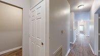 Located on Zebulon Road in Macon, Georgia, this single-story home offers four bedrooms and two bathrooms across a well-organized floor plan. The interior is finished with wood-look flooring throughout, complemented by neutral gray and beige tones on the walls, white panel doors, and clean white baseboards that create a consistent, cohesive aesthetic.

The kitchen is a galley-style layout equipped with warm-toned wooden cabinetry, light-colored countertops, and black appliances including a range, dishwasher, and refrigerator. An adjacent dining area features crown molding, chair rail detailing, and a chandelier overhead, adding a touch of formal character.

The living room includes a ceiling fan and connects naturally to the rest of the home. Each bedroom is finished with wood-look flooring and ceiling fans, with the primary bedroom offering access to a dedicated closet. Three closets are distributed throughout the home to support storage needs.

Both bathrooms are functionally appointed, with one featuring a tub-shower combination, wood-look tile flooring, a vanity with storage, and neutral wall tones. The hallways are well-proportioned, with a thermostat centrally located for easy climate control. Overall, the home presents a clean, move-in-ready environment with practical finishes.