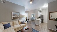 Located in Phoenix, AZ, this thoughtfully designed 2-bedroom, 2-bathroom residence offers a smart, open-concept floor plan that maximizes every inch of its single-level layout. Wood-look flooring flows through the main living areas, anchoring a bright living room with vaulted ceilings and a ceiling fan, which opens seamlessly into the dining area and kitchen. The dining space features a pendant light fixture and a large vertical-blind window that brings in natural light. The kitchen is well-equipped with white shaker cabinetry, light quartz countertops, stainless steel appliances including a refrigerator, range, and microwave, and a peninsula with an undermount sink. The primary bedroom offers plush carpet, elevated ceilings, and direct access to a private en-suite bathroom. A second bedroom provides similar comfort, while a dedicated office with large windows and carpeted floors adds valuable flexible space. Both bathrooms are finished with white cabinetry, quartz counters, and wood-look tile flooring, with one featuring a full tub-shower combination. Neutral gray tones throughout create a calm, cohesive ambiance suited to a variety of styles.