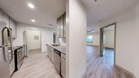 Located at 1970 Peachford Rd in Dunwoody, GA, this well-appointed two-bedroom, two-bathroom residence offers a thoughtfully designed single-floor layout. Light wood-look flooring flows consistently throughout the home, complementing the bright, neutral color palette.

The kitchen is a functional highlight, featuring gray shaker-style cabinetry extending to the ceiling for ample storage, granite countertops, a subway tile backsplash, and stainless steel appliances including a refrigerator, range, microwave, and dishwasher. The kitchen opens toward the dining and living areas, creating a cohesive, connected layout. The living room features a tray ceiling with a ceiling fan and access to natural light through large windows.

The primary bedroom is generously sized, showcasing its own tray ceiling, a ceiling fan, and direct access to an en-suite bathroom. Both bathrooms are finished with granite-topped vanities, gray cabinetry, and full tub-shower combinations framed by classic white subway tile. The second bedroom also benefits from tray ceiling detailing and a large window that brings in natural light.

Additional features include four closets offering plentiful storage and a dedicated in-unit laundry room, rounding out this clean and modern home in the heart of Dunwoody.