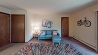 Located at 1210 Sweeney Dr in Middleton, Wisconsin, this single-floor residence offers a well-organized layout designed for comfortable everyday living. The living area is generously sized, featuring neutral-toned carpet, a vertical wood-panel accent wall, and room for multiple seating arrangements. Natural light filters through the windows, creating a bright and welcoming atmosphere throughout the space. A dedicated dining area with a ceiling fan sits adjacent to the kitchen, which is equipped with dark wood cabinetry, ample counter space, an electric range with overhead ventilation, and tile flooring. The unit includes two carpeted bedrooms, each featuring windows with views of surrounding greenery and baseboard heating. One bedroom includes a closet with wood-trimmed doors. Two full bathrooms serve the unit, both appointed with wide vanity countertops, shower-tub combinations, tile flooring, and ventilation. The floor plan flows efficiently between the living, dining, and private spaces, making the layout both practical and functional. A sliding window in one of the rooms opens to an outdoor balcony area, providing a pleasant connection to the outdoors. Overall, the space presents a clean, functional design well-suited for residential living in the Middleton area.