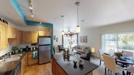 Located at 2451 S Timberline Rd in Fort Collins, Colorado, this single-floor residence offers a well-designed open-concept layout that seamlessly connects the kitchen, dining, and living areas. The kitchen is a standout feature, highlighted by a bold teal accent wall, warm maple cabinetry, dark granite countertops, a central island with pendant lighting, and a full suite of stainless steel appliances including a range, microwave, dishwasher, and refrigerator. Track lighting and wood-look flooring add a modern touch to the space. The living room is bright and inviting, featuring large windows that allow ample natural light, a ceiling fan, and sliding glass doors that open to an outdoor area. A dedicated dining space sits adjacent to the living room, creating a cohesive entertaining zone. The residence includes multiple bedrooms, each carpeted and fitted with windows that bring in natural light. The primary bedroom offers direct access to a private bathroom equipped with a soaking tub, shower combination, a single vanity, and wood-look flooring. A second full bathroom mirrors the same finishes. The overall design balances comfort and functionality throughout.