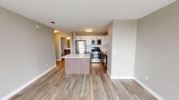Located at 400 E South Water St in Chicago's vibrant Streeterville neighborhood, this single-floor residence offers a well-designed, open-concept layout with contemporary finishes throughout. Light wood-tone flooring runs seamlessly across the living and kitchen areas, creating a warm and cohesive aesthetic.

The kitchen is a standout feature, equipped with a full suite of stainless steel appliances including a gas range, microwave, refrigerator, and dishwasher. Two-tone cabinetry combines white upper cabinets with rich walnut-finish lower cabinets, complemented by a light subway tile backsplash and quartz countertops. A central island with matching quartz surface and walnut-panel base provides additional prep space and casual seating.

The open living area benefits from floor-to-ceiling windows that invite natural light and offer city views, with a sliding glass door providing access to an outdoor balcony. The space maintains a clean, neutral color palette that enhances the sense of openness.

The bathroom is well-appointed with a full soaking tub and shower combination, a modern vanity with a quartz countertop, a framed mirror with accent lighting, and wood-look tile flooring that ties cohesively to the rest of the residence. Overall, the space presents a modern, move-in-ready environment in one of Chicago's most sought-after locations.