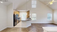 Located at 221 Fairforest Way in Greenville, SC, this single-floor, three-bedroom, three-bathroom home offers a well-designed layout with a range of notable architectural features. The open-concept living area is anchored by dramatic vaulted ceilings that soar overhead, flooding the space with natural light through multiple windows. Wood-style flooring runs throughout the living and dining areas, adding warmth and visual continuity.

The kitchen is a functional centerpiece, featuring granite-style countertops, a peninsula with a built-in sink, warm wood cabinetry, tile flooring, and black appliances including a refrigerator, range, and dishwasher. Pendant lighting above the peninsula enhances both style and utility. The kitchen flows seamlessly into the combined dining and living area, making it ideal for everyday living and entertaining.

The spacious primary bedroom includes plush carpeting, a ceiling fan, and direct access to a private en-suite bathroom with a vanity and tub-shower combination. The additional bedrooms also feature carpeted floors and generous proportions. All three bathrooms are consistently appointed with granite-style countertops, wood vanities, and tile flooring. A dedicated laundry area and multiple closets round out the practical amenities of this well-appointed home.