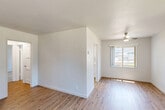 Located at 3500 Edison Street in San Mateo, California, this single-level, one-bedroom, one-bathroom unit offers a clean and efficiently designed layout across a compact but well-utilized floor plan. The living room is bright and welcoming, featuring light wood-tone flooring, white walls, a ceiling fan, and a large window that allows natural light to fill the space. A hallway connects the main living areas and provides a sense of defined flow throughout the unit. The kitchen is outfitted with white shaker-style cabinetry, light countertops, and stainless steel appliances, including a full-size refrigerator, creating a crisp and functional cooking space. The bedroom offers a comfortable footprint, carpeted flooring for added warmth, a sliding closet with built-in shelving and hanging rods, and a window that brings in natural light. The bathroom features a full tub-shower combination with a curved curtain rod, a single vanity with a modern brushed nickel faucet, a wall mirror, and a frosted privacy window. Throughout the unit, neutral tones, white trim, and consistent finishes create a cohesive and move-in-ready aesthetic suitable for comfortable everyday living in the heart of San Mateo.
