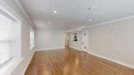 Located on Emanuel Cleaver II Blvd in Kansas City, MO, this single-floor, two-bedroom, one-bathroom residence offers a well-designed layout with quality finishes throughout. The living area is generously proportioned, featuring warm hardwood floors, crown molding, and recessed lighting that create a bright, polished atmosphere. A pass-through opening connects the living space to the kitchen, enhancing the open feel of the unit.

The kitchen is well-appointed with white shaker-style cabinetry, granite countertops, a classic white subway tile backsplash, and a full suite of stainless steel appliances including a gas range, dishwasher, and over-the-range microwave. Stone tile flooring completes the functional, clean aesthetic.

Both bedrooms continue the hardwood flooring and crown molding found throughout the home. Each room benefits from natural light via white-trimmed windows with blinds. One bedroom includes a sliding-door closet with built-in shelving. The bathroom features floor-to-ceiling white subway tile in the walk-in shower, a recessed niche, hexagonal mosaic tile flooring, and a small window for natural light—combining classic design with modern detail.