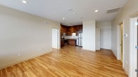 This two-bedroom, two-bathroom residence is thoughtfully designed across a single floor, offering a cohesive and functional layout. Light-toned hardwood flooring runs throughout the living spaces and bedrooms, lending warmth and continuity to the interior.

The open living area is bright and spacious, benefiting from large windows that frame elevated city views. The kitchen is well-equipped, featuring rich wood cabinetry extending to the ceiling, granite countertops, a stainless steel refrigerator, dishwasher, range, and built-in microwave, along with track lighting overhead.

Both bedrooms are generously sized with large windows that allow for ample natural light and continued city views. Each bedroom includes a walk-in closet fitted with wire shelving systems, providing versatile storage options.

The two bathrooms are finished with tile flooring and tiled shower enclosures. The primary bathroom includes a glass-door walk-in shower with mosaic tile flooring, while both bathrooms feature wood vanities with granite countertops, undermount sinks, and large mirrors. The overall aesthetic is clean, modern, and consistently appointed throughout.