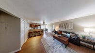 Located at 2021 Georgetown Pkwy in Fenton, Michigan, this well-appointed 2-bedroom, 2-bathroom single-floor residence offers a thoughtfully designed layout with a welcoming, functional flow throughout. The open-concept living area features rich hardwood-style flooring and neutral warm-toned walls, creating a bright and cohesive atmosphere. The living room provides ample space for relaxing and entertaining, opening seamlessly into the dining area, which benefits from large sliding glass doors that invite natural light and offer views of the surrounding green outdoor space. The kitchen is equipped with warm wood cabinetry, track lighting, white appliances, and a wraparound breakfast bar with seating — ideal for casual dining. The primary bedroom is generously sized, complete with plush carpeting, a sliding glass door to the outdoors, and a dedicated walk-in closet outfitted with built-in wire shelving for efficient storage. The second bedroom features an arched window that fills the room with natural light and offers vaulted ceiling detailing, adding architectural interest. Both bathrooms are finished with wood vanities and full mirrors. Three closets throughout the residence provide excellent storage. The overall ambiance is comfortable and practical, making this a well-rounded home in a serene Fenton setting.
