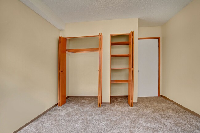 A bedroom with a closet and built in shelving - Alderview