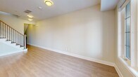 Located at 1265 Birchmount Rd in Toronto's Scarborough district, this contemporary multi-storey townhouse offers a well-organized layout spread across three floors. The main level hosts a spacious open-concept kitchen, dining, and living area, highlighted by a sleek kitchen with white cabinetry, a dark-topped island, subway tile backsplash, stainless steel appliances, and stylish pendant lighting. Light hardwood flooring flows throughout, complementing the bright, neutral palette of the interiors. A clean, tile-floored powder room with a pedestal sink is also conveniently located on this level. The second floor accommodates multiple rooms featuring large windows that invite abundant natural light and offer pleasant outdoor views of the surrounding Toronto neighbourhood. A full bathroom on this floor includes a soaker tub with classic white subway tile surround and chrome fixtures. Connecting all levels is a well-lit staircase with a contemporary wood-and-iron railing. The uppermost level opens to a rooftop terrace via large sliding glass doors, offering expansive city views — a standout feature of this property. Throughout, the space maintains a clean, modern aesthetic with crisp white walls, light hardwood floors, and thoughtful, functional design.