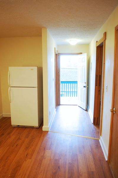 Hall from the kitchen out to deck. Bath with shower is on the left and smaller bedroom is on the right. The door in the kitchen holds the water heater and could have shelves added to be a small pantry. - 1728 I St