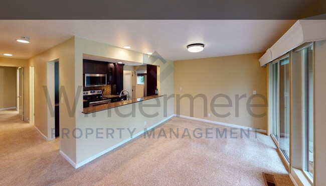 Dining area with sliding doors opening onto deck with BBQ. - 601 Village Way