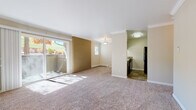 This single-floor residence offers a thoughtfully designed layout that balances comfort and functionality throughout. The open living and dining area serves as the heart of the home, featuring plush carpeting, crown molding, and a distinctive exposed brick accent wall that adds character and warmth. Large sliding glass doors flood the space with natural light and provide direct access to a private balcony overlooking lush, tree-lined scenery. A baseboard heating system ensures year-round comfort.

The galley-style kitchen is efficiently organized with dark espresso cabinetry, light countertops, stone tile flooring, and a full suite of appliances including a refrigerator, range, built-in microwave, and dishwasher — offering everything needed for everyday meal preparation.

The bedrooms are carpeted and finished with crown molding, neutral-toned walls, and generous closet space, including a double-door closet with built-in rod and shelf storage. Each room provides a calm, restful atmosphere with ample room to personalize.

The bathroom features stone tile flooring, a tub-shower combination with white tile surround, and a dark wood vanity, completing the home's cohesive aesthetic. Throughout the residence, clean finishes and a neutral color palette create a welcoming and move-in-ready environment.