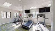 This fitness center is a comprehensively equipped space designed to support a wide range of workout routines. The room is finished with a distinctive geometric-patterned carpet in shades of gray, green, and yellow, lending a modern, energetic feel to the environment. White walls and a drop-tile ceiling with integrated skylights and recessed lighting panels ensure the space remains bright and welcoming throughout the day. Multiple windows along the walls allow natural light to pour in while offering views of the surrounding outdoor greenery.

The cardio zone features multiple treadmills and at least one upright stationary bike, each positioned to face wall-mounted flat-screen televisions for entertainment during workouts. Structural columns are integrated seamlessly into the layout without impeding the flow of the space. Full-length mirrors along one wall visually expand the room and allow users to monitor their form.

A dedicated strength-training area houses Life Fitness selectorized cable machines and weight stations. A separate functional training zone is stocked with an extensive free-weight rack offering kettlebells and dumbbells, a multi-functional rig with TRX suspension trainers, resistance bands, medicine balls, a BOSU balance trainer, stability balls, and a plyo box. A water fountain is also available within the space.