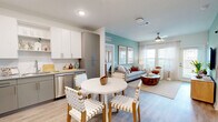 Located in Jacksonville, FL, this thoughtfully designed 2-bedroom, 2-bathroom residence offers a comfortable and modern living experience across a single floor. The open-concept layout seamlessly connects the kitchen, dining area, and living room, creating an inviting and functional common space. The kitchen is equipped with stainless steel appliances, granite countertops, white upper cabinetry, gray lower cabinets, a tile backsplash, and recessed lighting. A round dining table sits just off the kitchen, flowing naturally into the bright living room, which features a calming teal accent wall, light wood-style flooring, large windows with sheer curtains, and a ceiling fan that fills the space with natural light and airflow. The balcony extends the living space outdoors, offering picturesque views of a landscaped pond with a fountain and palm trees. The spacious primary bedroom features a bold terracotta accent wall, a ceiling fan, and wood-style flooring, while the second bedroom offers a serene, light-filled retreat. Both bathrooms are finished with granite vanity countertops and gray cabinetry. A dedicated laundry room accommodates a full-size washer and dryer. Two closets and a hallway round out this well-organized floor plan.