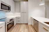 This contemporary condo in Tampa offers 890 square feet of thoughtfully designed living space. The open-concept layout showcases two bedrooms and three bathrooms, ideal for comfortable living or hosting guests. The kitchen is a highlight, featuring white cabinetry, stainless steel appliances, and a large island with pendant lighting, perfect for casual dining or entertaining.

Both bedrooms are generously sized, with the primary bedroom measuring 140 square feet. Each room is equipped with ceiling fans and large windows adorned with white blinds, allowing ample natural light while maintaining privacy. The bathrooms are stylishly appointed with modern fixtures, including a glass-enclosed shower and double vanity in the main bathroom.

Storage is plentiful throughout the unit, with two dedicated closet spaces featuring built-in shelving and hanging rods. The light wood-look flooring unifies the space, creating a warm and inviting atmosphere. The neutral color palette provides a blank canvas for personal decor preferences.

Located at 5301 W Tyson Ave, Unit 413, in Tampa, FL, this single-story condo combines functionality with modern aesthetics, offering a turnkey living experience in a desirable location.