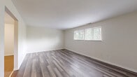 Located at 80 W Mill St in Springboro, Ohio, this single-floor residence offers three bedrooms, one bathroom, a kitchen, and a closet within a well-organized layout. Consistent grey-toned luxury vinyl plank flooring runs throughout the entire unit, providing a clean, cohesive aesthetic from room to room.

The spacious primary bedroom is notably generous in size, featuring a large sliding-door closet and access to the full bathroom, which is equipped with a tub-shower combination, a single vanity with wood cabinetry, and a wall mirror. The two additional bedrooms are bright and comfortable, each featuring windows that allow natural light and views of the surrounding greenery.

The galley-style kitchen is efficiently designed with dark wood cabinetry lining both walls, white countertops, a double sink, and white appliances including an electric range and refrigerator. An overhead range hood and ceiling light fixture complete the functional cooking space.

Throughout the unit, neutral cream-toned walls complement the flooring, creating a bright and airy atmosphere. The floor plan, as shown in the dollhouse view, reflects a straightforward and practical layout that maximizes the use of available space. This unit offers a comfortable and move-in ready living environment in Springboro, OH.
