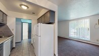 Located at 5327 Northfield Rd in Bedford Heights, Ohio, this single-floor unit offers a practical and functional layout across several well-defined living spaces. The galley-style kitchen is outfitted with dark gray cabinetry, a tile backsplash, granite-look countertops, a stainless sink, and white appliances including a refrigerator and dishwasher. Tile flooring runs throughout the kitchen and connects to a central hallway, providing easy access to the rest of the unit. The living area is generously sized, featuring wall-to-wall carpeting, a large window dressed with vertical blinds that allows natural light to fill the room, and baseboard heating. An additional carpeted room, accessible from the hallway, offers a comfortable and private retreat with its own access to the full bathroom. The bathroom is cleanly appointed with a white vanity, mirrored medicine cabinet, tile flooring, and a tub-shower combination with white tile surround. Throughout the unit, neutral white walls and straightforward finishes create a clean, move-in-ready atmosphere suited for everyday living.