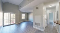 Located at 287 Cauncy St. in Mansfield, MA, this single-floor, 2-bedroom, 2-bathroom residence offers a thoughtfully designed layout with modern finishes throughout. The living area is bright and open, featuring light gray hardwood-style flooring, neutral-toned walls, and multiple windows that invite an abundance of natural light. Sliding glass doors provide additional access and views of the surrounding greenery, enhancing the airy atmosphere of the space.

The kitchen is well-equipped, showcasing warm wood cabinetry with arched detailing, polished granite countertops, and a full suite of appliances including a gas range, over-the-range microwave, and refrigerator — offering both style and functionality.

The primary bedroom stands out with striking vaulted ceilings that lend a sense of openness and volume, complemented by a large window overlooking wooded scenery. The second bedroom also features generous proportions and includes a double-door closet for ample storage.

Both bathrooms are finished with dark granite vanity tops, wood cabinetry, and sleek dark tile flooring. One bathroom includes a shower/tub combo with a glass enclosure, while the other features a walk-in shower. Connecting hallways provide a seamless flow throughout this well-appointed home.