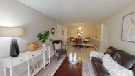 This modern 2-bedroom, 1.5-bathroom single-floor residence offers a thoughtfully designed layout that balances comfort and contemporary style. The open-concept living and dining area serves as the heart of the home, featuring light wood-style flooring, neutral warm-toned walls, and a sliding glass door that floods the space with natural light while providing direct access to an outdoor patio. The living room accommodates comfortable seating and stylish décor, creating an inviting atmosphere for relaxing or entertaining.

The adjacent dining area is defined by a ceiling fan overhead and a two-toned wall treatment with a chair rail, adding a refined architectural detail. It flows seamlessly into a functional kitchen equipped with light wood cabinetry, granite-style countertops, a double basin sink, and white Whirlpool appliances including a range and over-the-range microwave.

Both bedrooms feature plush carpeting, natural light from well-positioned windows with blinds, and ample space for furnishings. The bathrooms are clean and bright, with the half bath showcasing white cabinetry, a vanity mirror, and light wood-style flooring. Throughout the residence, the cohesive neutral palette and modern touches create a polished, move-in-ready living environment.