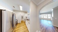 This thoughtfully designed 2-bedroom, 2-bathroom single-story home offers a comfortable and functional layout across a generously sized floor plan. The living area is a standout space, featuring rich wood-look flooring, elegant crown molding, a classic white fireplace, and an arched window that bathes the room in natural light. An arched architectural detail connects the living and additional living spaces, adding charm and visual continuity throughout.

The galley-style kitchen is both stylish and practical, outfitted with white shaker cabinetry, a subway tile backsplash, gray quartz countertops, stainless steel appliances including a refrigerator and range, and a stainless undermount sink. A skylight overhead floods the space with additional natural light, enhancing its bright and clean aesthetic.

Both bedrooms are carpeted for comfort and feature windows with blinds that bring in natural light. The spacious primary bedroom includes a ceiling fan and ample room for furnishings. The two bathrooms are finished with wood-look flooring, white cabinetry, gray countertops, and full tub-shower combinations with tile surrounds. Additional features include multiple hallways, two closets, and a well-organized overall flow that makes this home both practical and inviting.