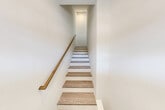 Located at 720 Eastview Drive in Central Islip, NY, this thoughtfully designed multi-level home spans three floors and offers 2 bedrooms, 2 bathrooms, and a versatile loft. The main living floor serves as the heart of the home, featuring an open-concept layout that seamlessly connects the kitchen, dining, and living areas. The kitchen is well-appointed with white shaker cabinetry, quartz countertops, a stainless steel sink, and stainless steel appliances including a gas range, built-in microwave, and dishwasher. Light-toned hardwood-style flooring flows throughout, complementing the crisp white walls and creating a clean, contemporary aesthetic. Large windows flood the living area with natural light while offering views of the surrounding community and lush green grounds. A private balcony extends the living space outdoors, overlooking well-maintained landscaped lawns. Both bathrooms are finished in bright white with marble-style tiled tub surrounds, vanities with ample storage, and modern chrome fixtures. The primary bedroom is generously sized, and the upper-level loft provides flexible additional space. Elegant wood-tread staircases with warm wooden handrails connect the floors, and the home also includes in-unit laundry, a utility room, and five closets for abundant storage.