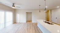 Located at 900 3rd St SE in Cedar Rapids, Iowa, this well-designed 2-bedroom, 2-bathroom unit offers a thoughtful single-floor layout with modern finishes throughout. The open-concept kitchen is a standout feature, showcasing white shaker cabinetry, light quartz countertops, and a full suite of stainless steel appliances including a French door refrigerator, electric range, built-in microwave, and dishwasher. Pendant lighting over the peninsula and recessed ceiling lights add a polished touch, while light-toned hardwood-style flooring flows seamlessly into the living area. The living space is bright and airy, benefiting from natural light and access to an outdoor balcony. Both bedrooms are generously sized, carpeted for comfort, and equipped with ceiling fans. The spacious primary bedroom connects to a walk-in closet fitted with wire shelving and hanging rods for ample storage. The two bathrooms are clean and functional, featuring white vanities, light wood-style flooring, and well-appointed fixtures — one with a walk-in shower and the other with a tub/shower combination. A connecting hallway ties the layout together efficiently, completing this polished and move-in ready home.