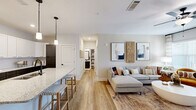 Located at 1035 Strensall Ln in Charlotte, NC, this thoughtfully designed one-bedroom, one-bathroom residence offers a comfortable and functional single-floor layout. Light wood-tone flooring flows throughout the open-concept living and kitchen areas, creating a cohesive and welcoming atmosphere.

The kitchen is a standout feature, showcasing white shaker cabinetry, dark lower cabinets, granite countertops, a subway tile backsplash, and a central island with bar seating for two. Stainless steel appliances, including a refrigerator, range, and microwave, complete this well-equipped space. Stylish pendant lighting adds a modern touch overhead.

The living room is bright and airy, benefiting from large windows that invite natural light and offer views of the outdoors. A ceiling fan, neutral walls, and direct access to the private balcony enhance the comfort of this space.

The bedroom features plush carpeting, multiple windows, a ceiling fan, and direct access to a walk-in closet. The full bathroom includes a dark-cabineted vanity with granite countertops, a large mirror, and wood-look flooring. A dedicated closet provides additional storage. The overall ambiance is clean, modern, and move-in ready.