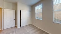 Located at 3000 Van Buren Blvd in Riverside, California, this single-floor residence offers a clean, modern aesthetic throughout. An elegant arched entryway leads into the open-concept living and kitchen area, where light wood-look flooring flows seamlessly underfoot. The kitchen is thoughtfully designed with crisp white shaker cabinetry, dark contrasting countertops, a classic subway tile backsplash, and stainless steel appliances including a gas range and built-in microwave. Recessed lighting illuminates the space, while an open passage connects the kitchen to the living area, enhancing the sense of openness. The bedrooms feature plush carpeting, ceiling fans, and windows fitted with horizontal blinds that allow natural light while offering privacy and views of the surrounding neighborhood. The primary bathroom is appointed with a dual-sink white vanity, brushed nickel fixtures, a large mirror, and a tall linen tower cabinet, with wood-look tile flooring adding warmth. A secondary bathroom includes a full soaking tub and shower combination with brushed gold hardware and clean white tile surround. Throughout the home, neutral tones and modern finishes create a cohesive, move-in-ready environment suited for comfortable everyday living.