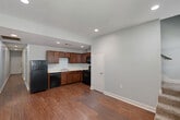Located on Gayosa Street in Baton Rouge, Louisiana, this two-story home offers a practical and well-organized layout spread across two floors. The main level serves as the social hub of the home, featuring an open living area and a functional kitchen equipped with rich medium-toned wood cabinetry, a double sink, and black appliances including a refrigerator, dishwasher, and range. Recessed lighting illuminates the space, which is finished with durable hardwood-style flooring throughout. A staircase leads to the upper level, where the three bedrooms are situated along connecting hallways. Each bedroom features plush carpeting, ceiling fans, and closets with sliding or hinged doors — providing comfortable and practical living spaces. The primary bedroom is generously sized with ample closet storage. The two bathrooms are consistent in design, featuring warm wood vanities with white countertops, tile flooring, and shower-tub combinations. One bathroom includes a double-sink vanity, adding convenience for shared use. Soft, neutral paint tones carry throughout the home, lending a clean and cohesive aesthetic to every room. The layout is efficient and functional, making good use of the available space across both floors.