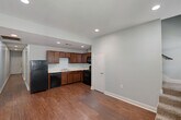 Located on Gayosa Street in Baton Rouge, Louisiana, this two-story home offers a practical and well-organized layout spread across two floors. The main level serves as the social hub of the home, featuring an open living area and a functional kitchen equipped with rich medium-toned wood cabinetry, a double sink, and black appliances including a refrigerator, dishwasher, and range. Recessed lighting illuminates the space, which is finished with durable hardwood-style flooring throughout. A staircase leads to the upper level, where the three bedrooms are situated along connecting hallways. Each bedroom features plush carpeting, ceiling fans, and closets with sliding or hinged doors — providing comfortable and practical living spaces. The primary bedroom is generously sized with ample closet storage. The two bathrooms are consistent in design, featuring warm wood vanities with white countertops, tile flooring, and shower-tub combinations. One bathroom includes a double-sink vanity, adding convenience for shared use. Soft, neutral paint tones carry throughout the home, lending a clean and cohesive aesthetic to every room. The layout is efficient and functional, making good use of the available space across both floors.