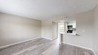 This one-bedroom, one-bathroom residence in Orlando, FL offers a well-designed, single-floor layout with modern updates throughout. The open-concept living and kitchen area is anchored by light gray wood-look flooring and neutral warm-toned walls, creating a clean, cohesive aesthetic. The kitchen features white cabinetry, a mosaic tile backsplash, black stainless appliances including a refrigerator and microwave, and a peninsula counter that serves as both a prep space and casual dining area. A textured popcorn ceiling adds a classic touch throughout the unit. The spacious bedroom is filled with natural light from a sliding glass door that opens directly onto a private balcony. From the balcony, residents enjoy an expansive view of a serene pond, lush green lawn, and mature trees — a standout feature of this unit. The bedroom also includes a closet and connects seamlessly to the rest of the layout. The bathroom has been tastefully updated with a white vanity, quartz countertop, matte black fixtures, and a backlit LED mirror that adds both function and a contemporary flair. Overall, the unit presents a bright, refreshed interior paired with tranquil outdoor views.