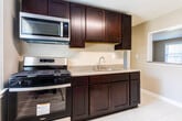 Located at 1086 Stuyvesant Ave in Irvington, NJ, this single-floor unit offers a well-organized layout with a clean, neutral aesthetic throughout. Warm-toned hardwood flooring extends across the living areas, hallways, and bedrooms, lending a cohesive and inviting feel to the space.

The kitchen is a functional standout, outfitted with rich dark-wood cabinetry, granite-style countertops, and stainless steel appliances including a gas range, over-the-range microwave, and sink. Light tile flooring and a large window allow natural light to brighten the space, making it both practical and pleasant for everyday use.

The bedrooms are generously proportioned with soft gray walls, gleaming hardwood floors, and white-trimmed doors. One bedroom features a pair of closets side by side, offering ample storage, while another benefits from a window with views of the surrounding neighborhood. A hallway with hardwood flooring connects the rooms efficiently, maintaining an easy flow throughout the unit.

The bathroom is clean and well-appointed, featuring white tile flooring, a window for natural light and ventilation, a tiled shower/tub surround, and neutral warm-toned walls. The overall ambiance of the unit is bright, tidy, and move-in ready.