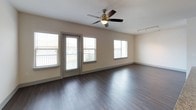 This 1-bedroom, 1-bathroom residence offers a thoughtfully designed, single-level floor plan with contemporary finishes and a cohesive modern aesthetic. Rich, dark hardwood-style flooring runs throughout the main living areas, anchoring the open-concept layout that seamlessly connects the living room, dining area, and kitchen.

The kitchen is a standout feature, outfitted with dark espresso cabinetry, granite countertops, a classic subway tile backsplash, and a full suite of stainless steel appliances, including a French door refrigerator, range, and over-the-range microwave. A built-in wine rack adds a distinctive touch above the refrigerator, while pendant and track lighting enhance the space's modern character. A breakfast bar provides additional countertop space and casual seating.

The living room is bright and inviting, with multiple windows allowing generous natural light and a door leading to a private balcony. A ceiling fan with light kit adds both comfort and style.

The bedroom is carpeted for warmth and comfort, features a ceiling fan, and is served by a spacious walk-in closet with built-in shelving and dual hanging rods offering ample storage.

The bathroom is finished with dark tile surrounds in the shower-tub combination, granite countertops, dark wood cabinetry, and hardwood-style flooring. An in-unit laundry area with a full-size washer and dryer completes this well-equipped residence.