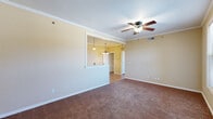 Located at 1719 Sky Point Bend in Van Buren, Arkansas, this single-story home offers a comfortable and functional layout with thoughtful design details throughout. The living area is generously sized, featuring warm-toned carpet, crown molding, and a ceiling fan with light fixture. A pass-through window connects the living space to the kitchen, enhancing the open feel while pendant lighting adds a welcoming touch.

The kitchen is well-equipped, showcasing rich oak cabinetry, a brick-style tile backsplash, and durable hardwood-style flooring. White appliances — including a range, microwave, refrigerator, and dishwasher — are neatly integrated, and ample counter space makes meal preparation convenient. Crown molding carries through into the kitchen, adding a refined finish.

The bedrooms are carpeted and each include ceiling fans. One bedroom features a large window with natural light and a neighborhood view, while another includes a closet with built-in shelving. The bathroom is outfitted with warm oak vanity cabinetry, a wide countertop, a large mirror, and hardwood-style flooring, with direct access to the adjacent bedroom and closet. A dedicated laundry area accommodates a full-size washer and includes an overhead utility shelf, rounding out this practical and well-maintained home.