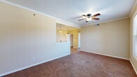 Located at 1719 Sky Point Bend in Van Buren, Arkansas, this single-story home offers a comfortable and functional layout with thoughtful design details throughout. The living area is generously sized, featuring warm-toned carpet, crown molding, and a ceiling fan with light fixture. A pass-through window connects the living space to the kitchen, enhancing the open feel while pendant lighting adds a welcoming touch.

The kitchen is well-equipped, showcasing rich oak cabinetry, a brick-style tile backsplash, and durable hardwood-style flooring. White appliances — including a range, microwave, refrigerator, and dishwasher — are neatly integrated, and ample counter space makes meal preparation convenient. Crown molding carries through into the kitchen, adding a refined finish.

The bedrooms are carpeted and each include ceiling fans. One bedroom features a large window with natural light and a neighborhood view, while another includes a closet with built-in shelving. The bathroom is outfitted with warm oak vanity cabinetry, a wide countertop, a large mirror, and hardwood-style flooring, with direct access to the adjacent bedroom and closet. A dedicated laundry area accommodates a full-size washer and includes an overhead utility shelf, rounding out this practical and well-maintained home.