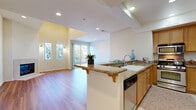 Located in Sun Valley, Los Angeles, this 2-bedroom, 5-bathroom residence offers a well-designed single-level layout that maximizes comfort and functionality. The open-concept living and kitchen area serves as the heart of the home, where soaring ceilings and large sliding glass doors fill the space with natural light and provide direct access to a private balcony with outdoor views. The living room features warm hardwood-style flooring, a tile-surround fireplace, and tall vertical windows that enhance the airy, spacious feel.

The kitchen is outfitted with granite countertops, warm wood cabinetry, stainless steel appliances including a gas range, built-in microwave, and refrigerator, plus a peninsula with bar seating and an integrated dishwasher. Tile flooring runs throughout the kitchen for easy maintenance.

Both bedrooms are carpeted and receive natural light through well-positioned windows. The generously sized primary bedroom includes access to a well-appointed en-suite bathroom featuring a dual-sink vanity with warm wood cabinetry, a large mirror, and tile flooring. Additional bathrooms offer tub-shower combinations with clean white tile surrounds. Three closets, including a spacious walk-in with built-in shelving, provide ample storage throughout the residence.