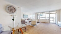 Located in the heart of Oakland, CA (94612), this well-appointed one-bedroom, three-bathroom residence offers a thoughtfully designed single-floor layout with an open, airy feel throughout. Floor-to-ceiling windows in the living room and dining area flood the space with natural light while framing sweeping urban views of the Oakland skyline. The living area features plush carpeting, a neutral color palette, and generous proportions ideal for both relaxing and entertaining. A separate dining nook complements the open-concept flow. The kitchen is efficiently designed with warm wood cabinetry, granite countertops, stone tile flooring, and white appliances, providing ample storage and counter space. The spacious primary bedroom is a tranquil retreat, featuring large windows with city views, soft carpeting, and access to a dedicated bathroom. An additional room with balcony access offers flexibility as a home office or den. All three bathrooms are finished consistently with granite-topped wood vanities, stone tile floors, and clean, bright aesthetics. A hallway connects the rooms seamlessly, contributing to an efficient and functional floor plan. This residence combines comfort and urban convenience in a bright, well-maintained setting.