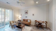 Located at 1600 Granby Street in Norfolk, VA, this one-bedroom, one-bathroom unit offers a well-designed single-floor layout that maximizes its intimate footprint. The open-concept living and kitchen area serves as the heart of the home, featuring hardwood-style flooring throughout. The living room is bright and airy, with crown molding, a ceiling fan, and a large sliding glass door that fills the space with natural light and provides access to an outdoor area. A dedicated dining nook sits adjacent to the living space, adding functional versatility. The kitchen is thoughtfully appointed with light wood cabinetry, granite-style countertops, stainless steel appliances including a full-size refrigerator and range, and a peninsula with a undermount sink — ideal for both cooking and casual dining. The spacious primary bedroom features soaring vaulted ceilings, plush carpeting, a ceiling fan, and a large window with ample natural light. It connects directly to the bathroom, which offers a dual-sink vanity with granite countertops and warm wood cabinetry. Neutral tones and consistent finishes throughout create a cohesive, modern aesthetic well-suited for comfortable urban living in downtown Norfolk.