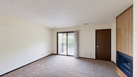 Located at 4826 Jersey Ridge Rd in Davenport, Iowa, this two-bedroom, one-bathroom unit is thoughtfully laid out across a single floor. The living room serves as a welcoming focal point, featuring a wood-paneled accent wall with a built-in fireplace that adds warmth and character to the space. Soft carpeting runs throughout the living and bedroom areas, contributing to a comfortable, cohesive feel.

The spacious primary bedroom is notably generous in size and includes sliding glass doors that open onto a private balcony, offering pleasant outdoor views of surrounding greenery. A textured ceiling and neutral cream walls are consistent throughout, providing a clean, understated backdrop. The second bedroom features a large window that invites natural light, making it a bright and versatile space.

The kitchen is well-equipped with dark wood cabinetry, laminate countertops, a double-basin sink, and white appliances including a range and refrigerator. Recessed lighting and tile flooring give the kitchen a functional and tidy appearance. A ceiling fan with light fixture is also present in the kitchen area.

The bathroom includes a full tub-shower combination with a clean, white surround. Overall, the unit offers a practical and comfortable layout suited for everyday living.