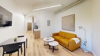 Located at 440 Monroe Ave in Memphis, TN, this one-bedroom, one-bathroom unit offers a thoughtfully designed single-floor layout with a clean, contemporary aesthetic. Light wood flooring runs throughout, complementing the bright white walls and modern linear lighting to create an airy, cohesive feel.

The open living area serves as the heart of the unit, featuring wall-mounted flat-screen TV, a compact dining area with a window that brings in natural light, and a comfortable seating arrangement with round accent tables. Exposed industrial-style ductwork on the ceiling adds a subtle urban character to the space.

The kitchen is efficiently integrated along one wall, featuring wood-toned cabinetry, a stainless steel sink, and compact appliances — maximizing functionality within the footprint.

The bedroom is an intimate, well-appointed retreat with a wall-mounted TV, built-in closet with double doors, and clean white walls accented by a large framed artwork. Soft pendant lighting enhances the calm atmosphere.

The bathroom is finished with white tile in a tub-shower combination, light wood flooring continued from the main living areas, and chrome fixtures, maintaining a consistent, polished look throughout the unit.