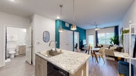Located at 101 Pine Forest Rd in Augusta, Georgia, this single-floor residence offers a well-designed, open-concept layout with modern finishes throughout. The kitchen serves as a central highlight, featuring granite countertops, a large island with a stainless steel sink, light wood cabinetry, and black appliances including a range, microwave, and refrigerator. Pendant lighting adds a stylish touch, while durable wood-look flooring extends throughout the main living areas. A bold teal accent wall creates a vibrant visual connection between the kitchen and the adjoining dining and living spaces. The living room is bright and welcoming, with natural light flowing in through windows dressed with blinds and curtains, complemented by a ceiling fan overhead. The bedrooms are carpeted for comfort and feature generous windows that bring in ample natural light, ceiling fans, and soft, neutral tones that create a restful atmosphere. The bathroom is cleanly appointed with granite vanity countertops, light wood cabinetry, wood-look flooring, and a tiled shower-tub combination. The exterior grounds include mature trees and landscaped greenery, contributing to a serene setting.