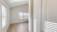 Located on Fullerton Drive in Huntsville, Alabama, this single-story, one-bedroom, one-bathroom home offers a thoughtfully designed layout with modern finishes throughout. Light-toned luxury vinyl plank flooring flows consistently across all rooms, lending a clean and cohesive aesthetic.

The living room is a standout space, featuring soaring vaulted ceilings with transom windows that flood the room with natural light, complemented by a ceiling fan. Large windows provide views of the surrounding neighborhood, enhancing the sense of openness.

The kitchen is well-appointed with gray shaker-style cabinetry, a herringbone tile backsplash, white quartz countertops, and a full suite of stainless steel appliances including a refrigerator, range, and microwave. A peninsula with a pendant light and undermount sink adds both function and style.

The bedroom is generously proportioned, featuring vaulted ceilings and multiple windows that bring in ample natural light. A dedicated closet offers practical storage. The full bathroom mirrors the kitchen's design aesthetic with matching gray cabinetry, a white quartz vanity top, and a tub-shower combination. The entrance and hallway complete this efficiently arranged home, making it a bright and modern living space in Huntsville, AL.