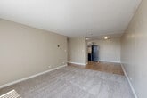 Located at 4185 E Florida Ave in Denver, CO, this one-bedroom, one-bathroom unit offers a practical and comfortable single-floor layout. The open-concept living and dining area is bright and inviting, featuring neutral beige walls, plush carpet, and large windows with vertical blinds that allow generous natural light to filter in. Wood-look flooring transitions seamlessly into the kitchen and hallway areas, adding warmth and visual continuity throughout.

The kitchen is efficiently designed with white cabinetry, granite-style countertops, a stainless steel refrigerator, and matching appliances, including a dishwasher and range. A ceiling-mounted light fixture keeps the space well-lit. The hallway connects the main living area to the bedroom and bathroom, featuring textured walls and a flush-mount ceiling light.

The bedroom is a well-sized, carpeted retreat with a window for natural light, a wall-mounted heating unit, and access to multiple closets, providing ample storage. The bathroom is clean and functional, appointed with brushed nickel fixtures, grab bars, and a classic white toilet. Overall, the unit presents a neutral, move-in-ready aesthetic suited for comfortable everyday living.