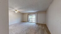 This 2-bedroom, 2-bathroom single-floor residence offers a functional and comfortable layout across a well-utilized footprint. The open-concept living, dining, and kitchen area serves as the heart of the home, featuring plush wall-to-wall carpeting, a ceiling fan with light fixture, and a textured ceiling. A sliding glass door opens to a private balcony overlooking lush tree canopy, filling the space with natural light and greenery views.

The kitchen is equipped with warm wood-toned cabinetry, a double-basin sink, a dishwasher, and a full-size refrigerator, complemented by a tile floor and an adjacent pantry for additional storage.

The primary bedroom is generously sized, featuring carpet flooring, a window with outdoor views, and direct sliding door access to the balcony. The second bedroom also offers carpet flooring and a window with natural light. Both bedrooms are supported by well-appointed closets with wire shelving systems, and the unit includes a total of four closets throughout.

The two full bathrooms each feature a tub-shower combination, tile flooring, and vanity with storage. A dedicated laundry area and a hallway connecting the rooms round out the practical layout of this thoughtfully designed residence.
